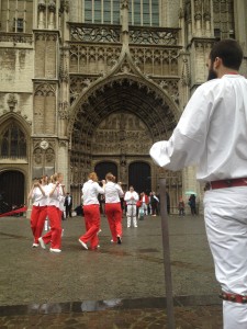 Lange Wapper's women's team dances in front of Antwerp Cathedral while a the men's team watches.
